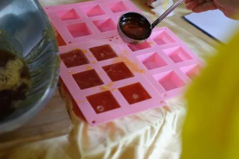 Hand pouring soap mixture on plastic form Stock Photos
