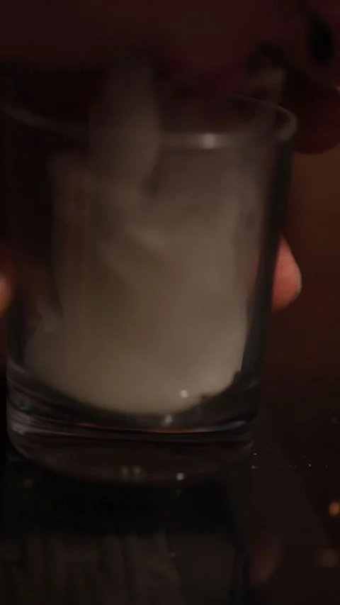 Hand pouring thick white smoke from a glass Stock Footage 333786570