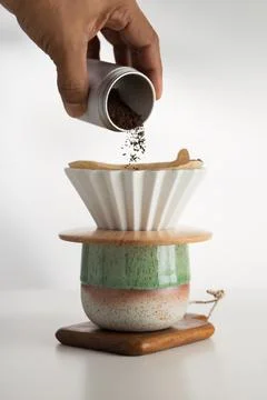 Hand pours coffee grounds for precision brewing. Foto stock