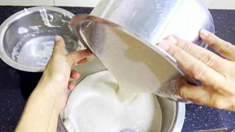 Hand Pours Creamy Mix Between Two Bowls Stock Footage 305960486