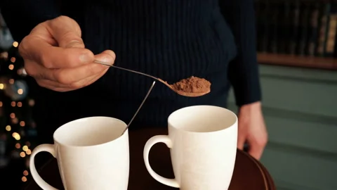 Hand pours ground coffee from a spoon in a coffee cup. Stock Footage 103226061