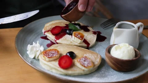 Hand pours jam on pancake. Stock Footage 272910460
