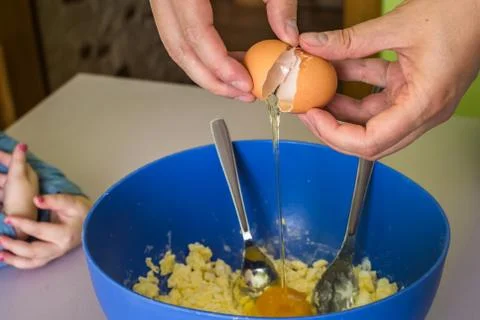 Hand pours out raw egg of the shell Foto stock