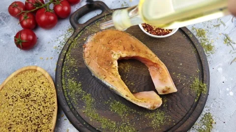Hand pours salmon steak with olive oil Stock Footage 155478016