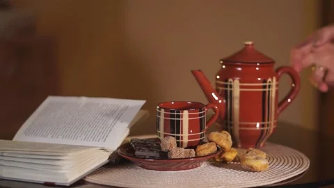 Hand pours tea from the teapot into a Cup  Stock Footage 134886839