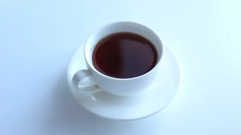 The hand pours a teaspoon of sugar into the tea and stirs. Stock Footage 168935089