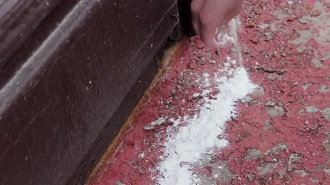 Hand pours white powder on the threshold of the house Stock Footage 79006935