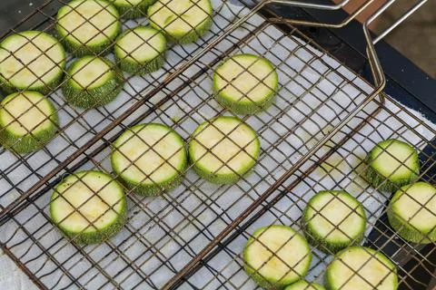 Hand prepares raw sliced vegetables - zucchini, squash, eggplant roasting on the Stock Photos