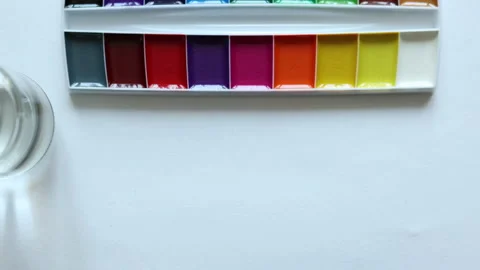 Hand preparing for art lesson or painting class glass of water aquarelle paints Stock Footage 157895320