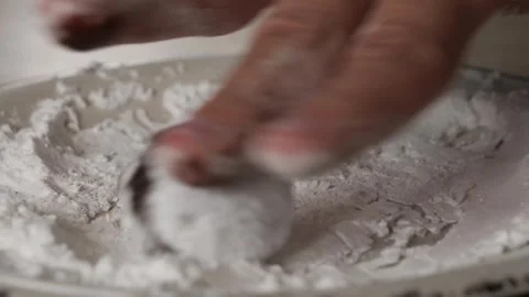 Hand preparing cracked marble biscuits with flour in a cozy kitchen setting Stockbeeldmateriaal 293016595