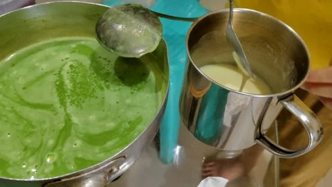 Hand Preparing Green Dish With Two Metal Containers and Utensils Stock Footage 305851070