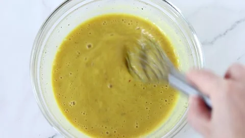 Hand is preparing homemade salad dressing with a whisk in a bowl Stock Footage 325434622