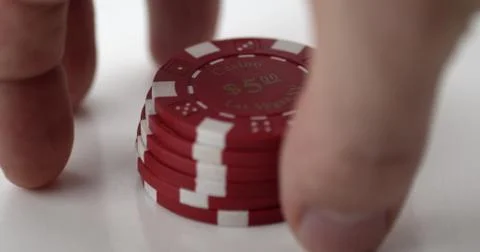 Hand preparing to pick up a short stack of red poker chips Stock Photos