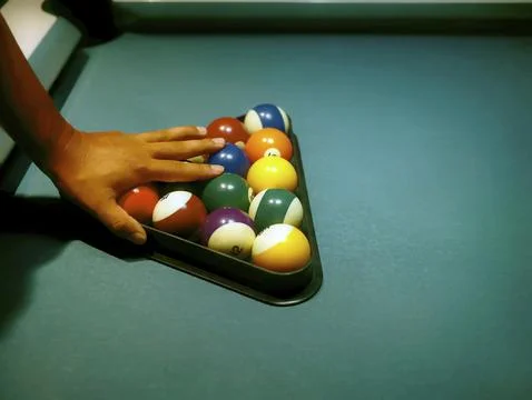 Hand preparing pool balls in triangle rack on the billiard table Stock Photos