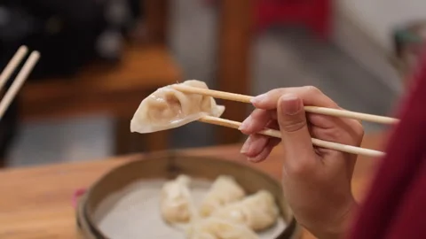 Hand preparing steamed dumplings at home kitchen table. Warm traditional kitchen Stock Footage 337318052