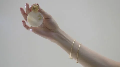 Hand presenting beautiful earrings against a plain background Stock Footage 319924467