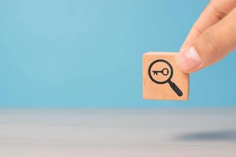 Hand presents cubes featuring key and magnifying glass icons. Concept of br.. Stock Photos