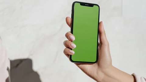 Hand presents green-screen device on minimal background Video stock 317167457