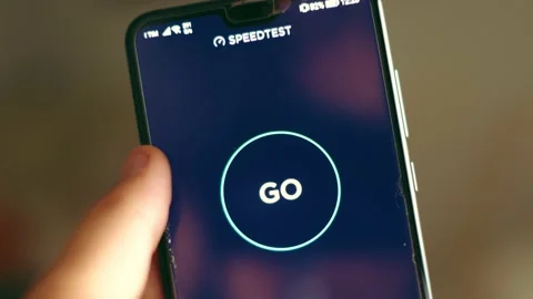 Hand press GO button connection speed test Speedtest app mobile phone Stock Footage 137867417
