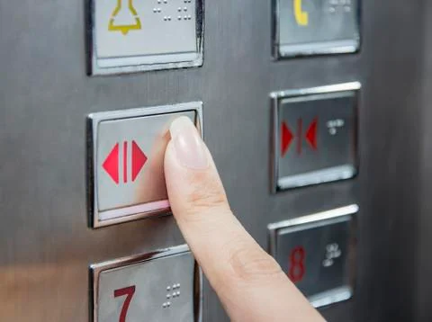 Hand press open door button in elevator Stock Photos
