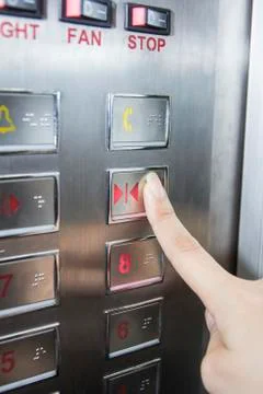 Hand press open door button in elevator Stock Photos