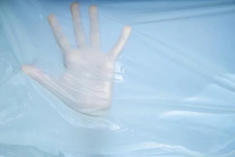 The hand is pressed against the bag. The hand tries to escape from the captivity Stock Photos