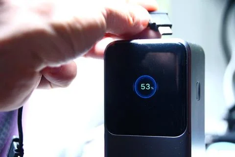 Hand presses a button on a black electronic device Fotos Stock