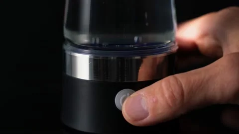 The hand presses a button in the ionization device, bubbles rise. Structuring Stock Footage 156798169