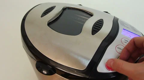 Hand presses buttons on bread machine's panel for baking Stock Footage 27245602