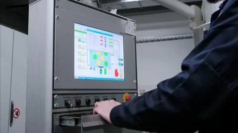 The hand presses the buttons on the control panel of the CNC machine. Factory Stock Footage 172112627