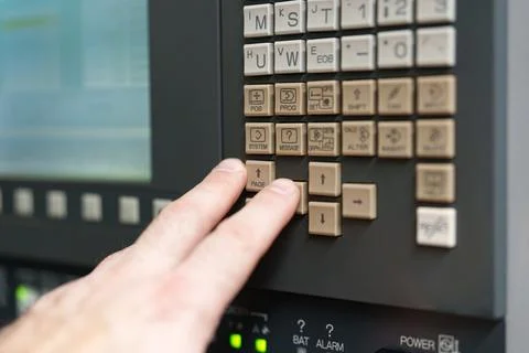 Hand presses buttons on a control panel in a factory during machine operati.. Stock Photos