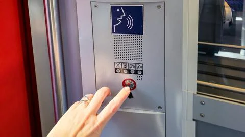  Hand presses circular silver button on metallic intercom panel with blue. Stock Photos