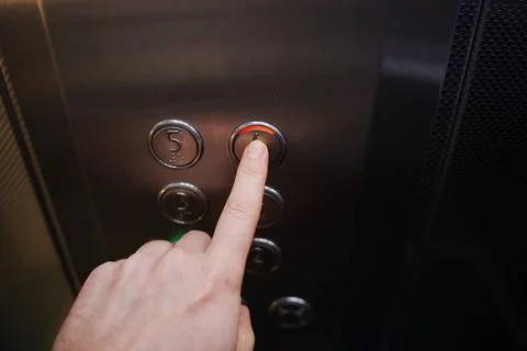 Hand presses elevator button to go to upper floor Stock Photos