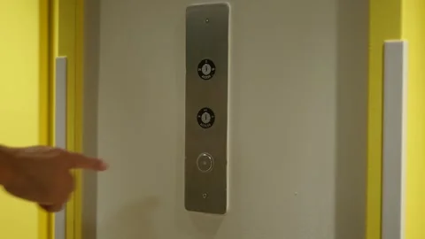 Hand presses illuminated elevator button, signaling a journey begins Stock Footage 345442812
