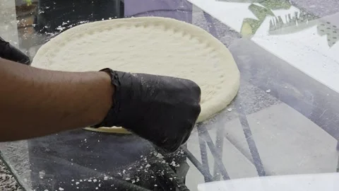 Hand presses knuckles into raw pizza dough to create dimples. Stock Footage 323866506