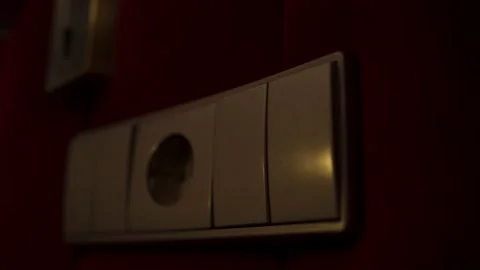 A hand presses the light switch in a hotel room. The light turns on and off Stock Footage 164559526