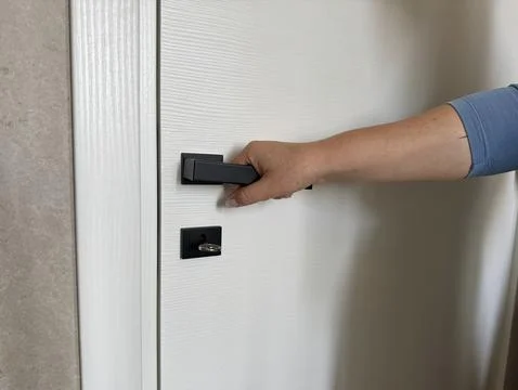 Hand presses a modern black handle Photos