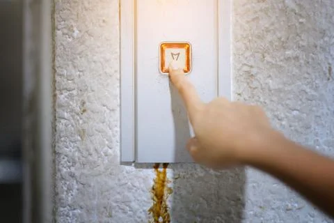 The hand presses on the old elevator button, Red button.  Close up shot and f Stockfoto's