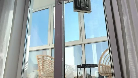 Hand presses remote activating robot cleaner on window glass during sunny d.. Stock Footage 333143772