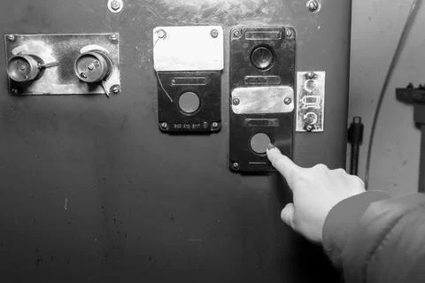 Hand presses the start button at the factory Stock Photos