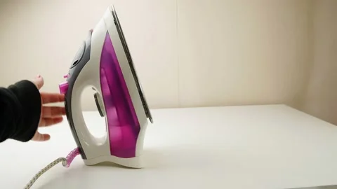 The hand presses the steam button on the iron.. Stock-Footage 130452209