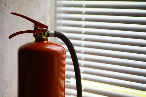 Hand presses the trigger fire extinguisher available in fire emergencies co.. Stock Photos