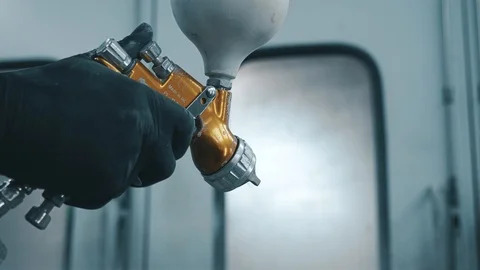 Hand presses the trigger of an orange spray gun Stock Footage 104497677