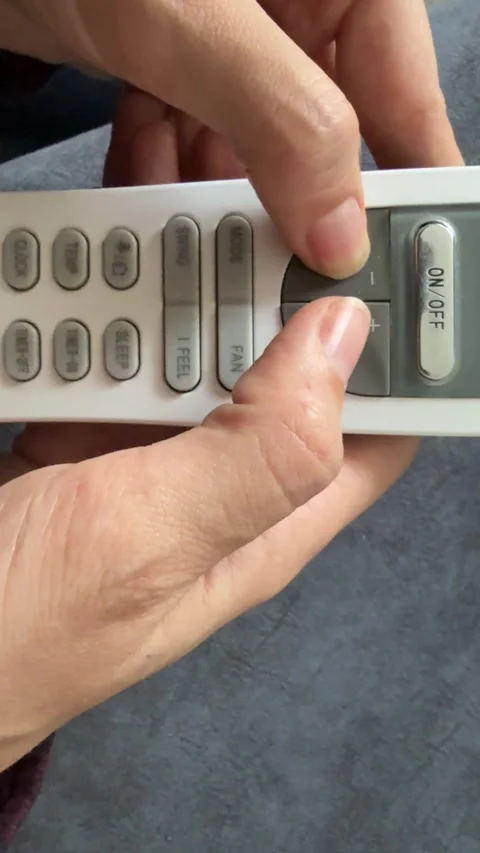 Hand pressing button on air conditioner remote control, home climate management Stock Footage 337119945