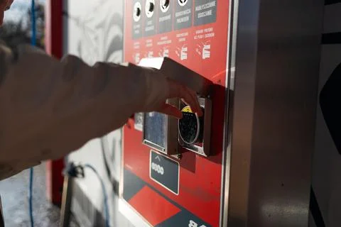 Hand pressing button on automated vending machine at manual carwash station. Stock Photos