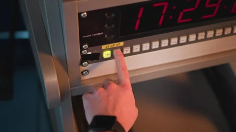Hand pressing button on control panel with timer in studio setting Stock Footage 317544579