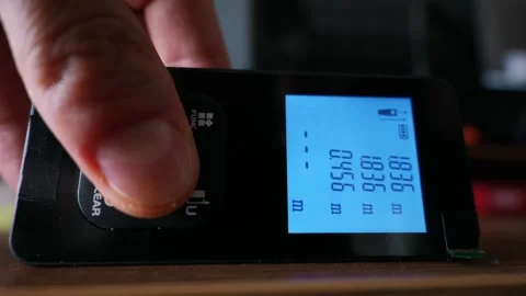 Hand Pressing Button on Digital Laser Distance Meter in Low Light Stock Footage 339362082