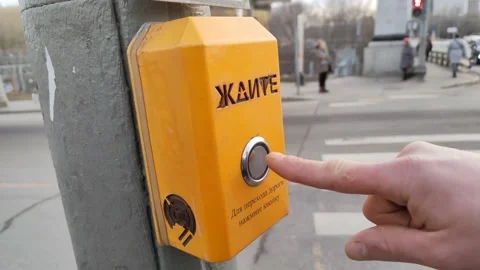 A hand pressing a button at a traffic light at a pedestrian crossing Stockbeeldmateriaal 177645508