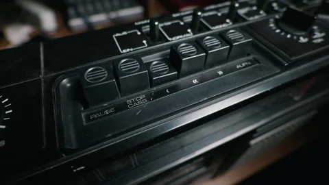 Hand Pressing a Button on a Vintage Black Cassette Player in a Dark Room 動画素材 334115997