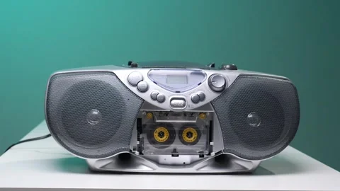 Hand pressing a button on a vintage silver boombox with an open cassette deck Stock Footage 345531060